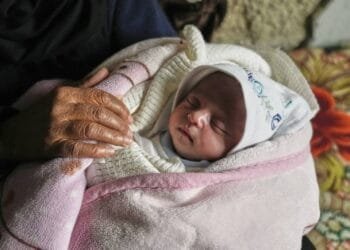 A month-old girl is pulled from rubble in Gaza after an airstrike killed her parents