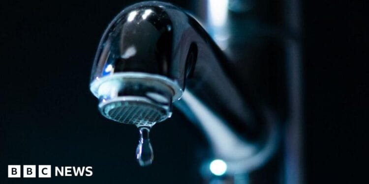 Keir Starmer, in a white lab coat, points at a computer screen, watched by a young man and women in lab coats and safety goggles. He is on a visit to the Manufacturing Futures Lab at University College London
