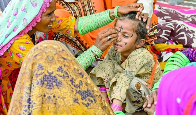 Fading ink of tradition 1 tattoo artist guddi manthar draws an indigenous tattoo on seven year old champa s face at the jogi colony in umerkot photo afp