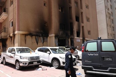 A member of the Kuwaiti security forces stands outside the building in Mangaf. AFP