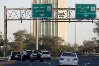 Cars drive past Kuwait's main government electricity control tower, where a thermometer placed on the building reads 47°C, on Wednesday.  AFP