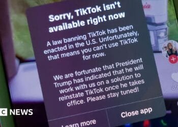 Young man and old woman hold sunflowers