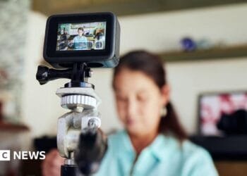 Prince Harry walks through an outdoor green space, wearing a suit and tie, while looking away from camera, taken in Johannesburg in October.