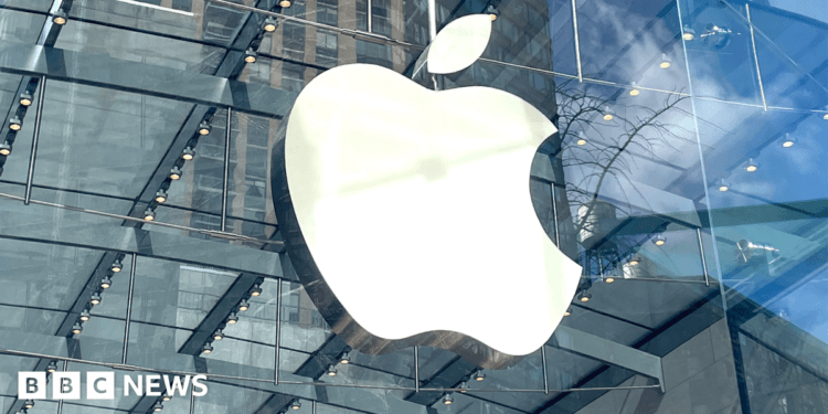 The apple logo on a clear round store is visible in amongst the skyscrapers in a city